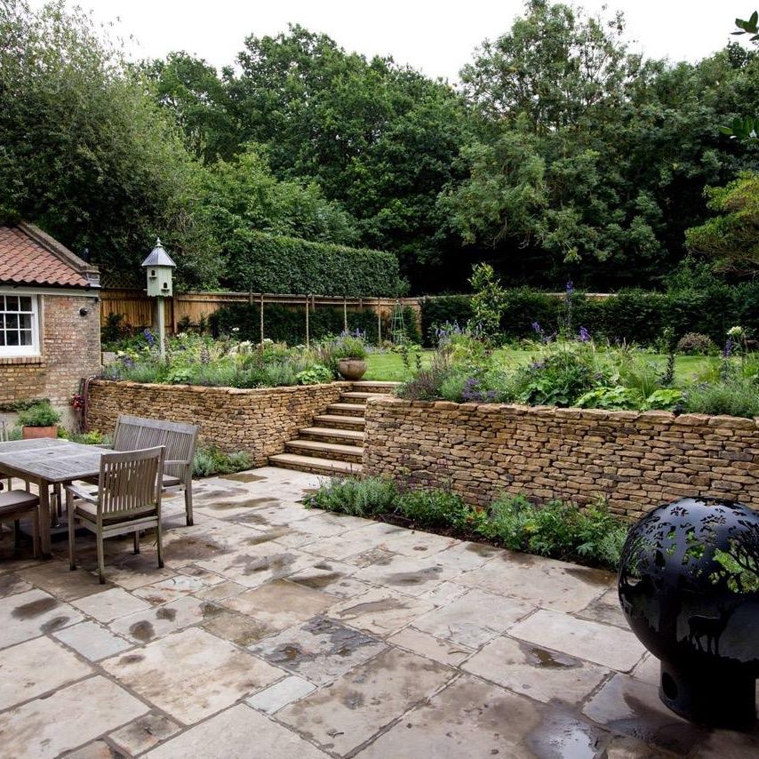 Large back garden with dry stone wall and patio area